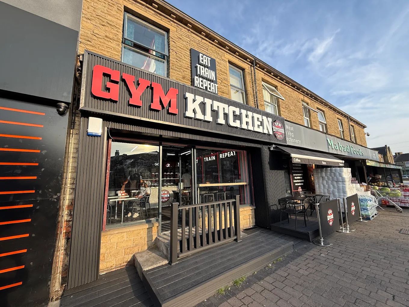 Gym Kitchen café storefront in Bradford with bold red and white signage